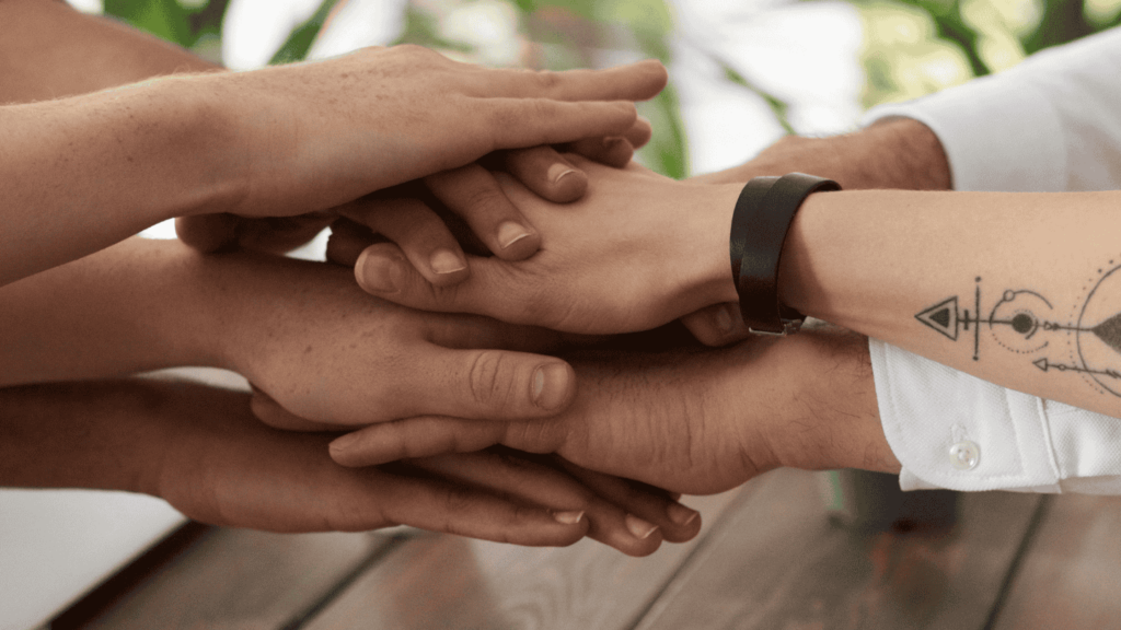 detalle de diferentes manos de personas unidas, haciendo equipo