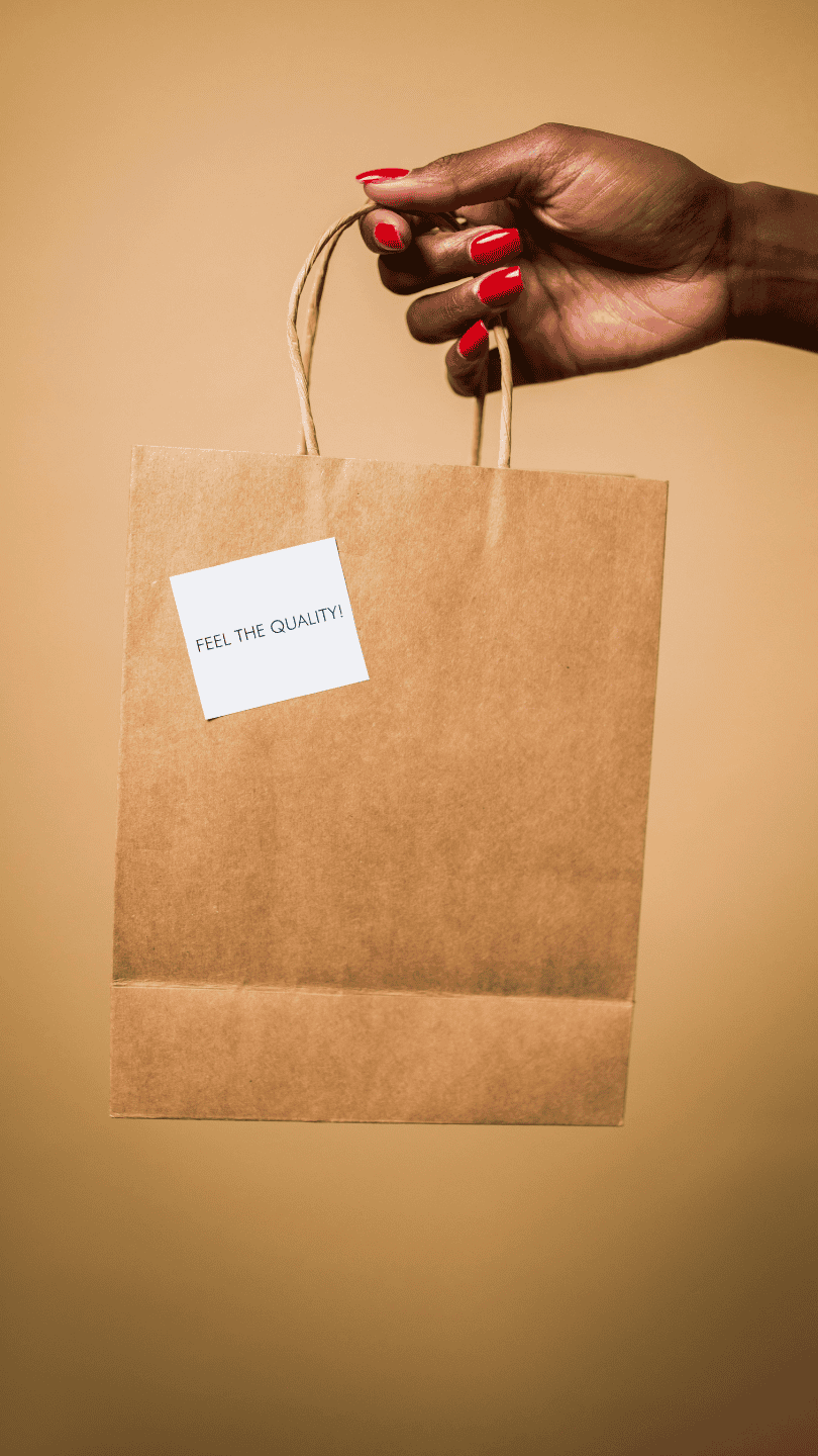 detalle de una mano cogiendo una bolsa de papel kraft