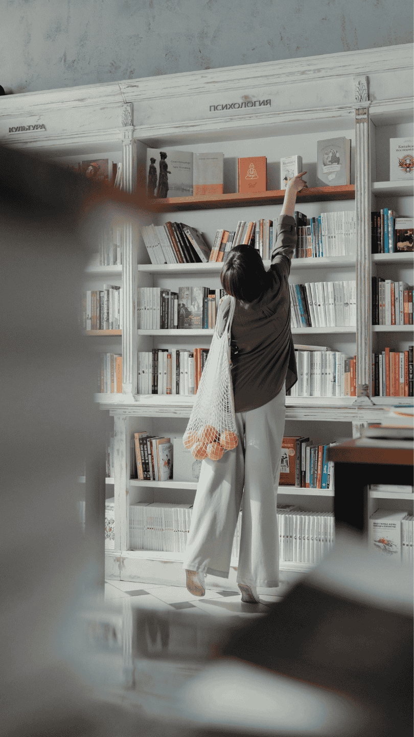 detalle de una mujer escogiendo un libro en una librería