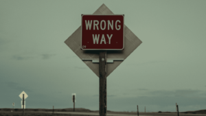 detalle de un camino con una señal indicando wrong way
